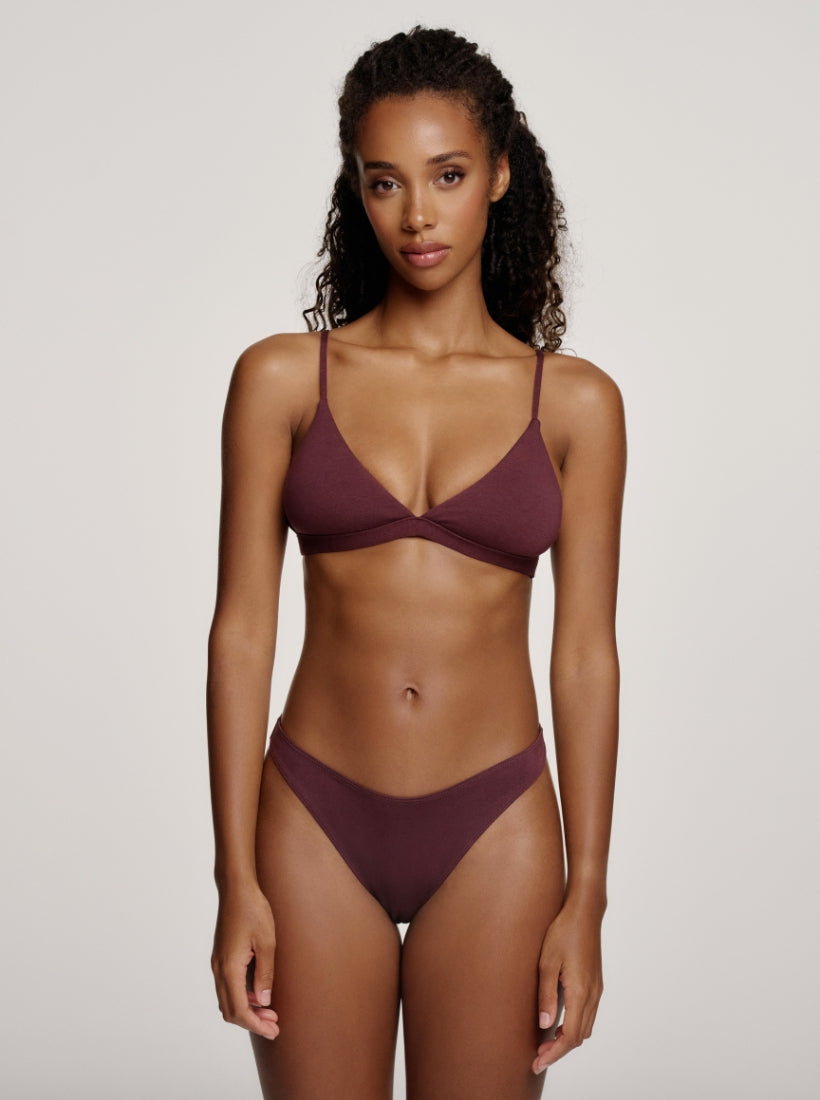 Model trägt aubergine braunen Triangle Bralette und Tanga die figurbetont und natürlich am Körper sitzen 