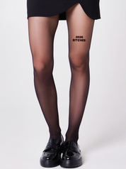 Schwarze 40 Den Strumpfhose von saintsass mit Statement  2026 Bitches auf vorderem rechten Oberschenkel 