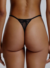 Rückansicht des Saint Sass Gigi Mesh Tanga mit Cut Outs in Schwarz, figurbetonte Passform mit transparentem Mesh, vor neutralem Hintergrund.