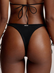 Rückansicht von schwarzen Chloe Bikini Bottoms mit silbernen saint sass Metalllogo in der Mitte oben