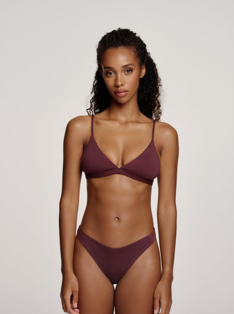 Model trägt aubergine braunen Triangle Bralette und Tanga die figurbetont und natürlich am Körper sitzen 