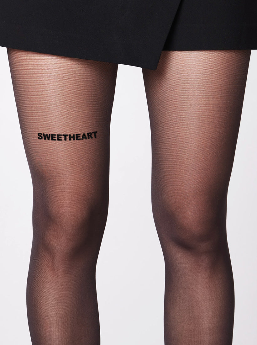 Die Statement Strumpfhose von saint sass mit dem Statement Sweetheart vorderen Oberschenkel. In 40 den und semi-transparenter Optik.